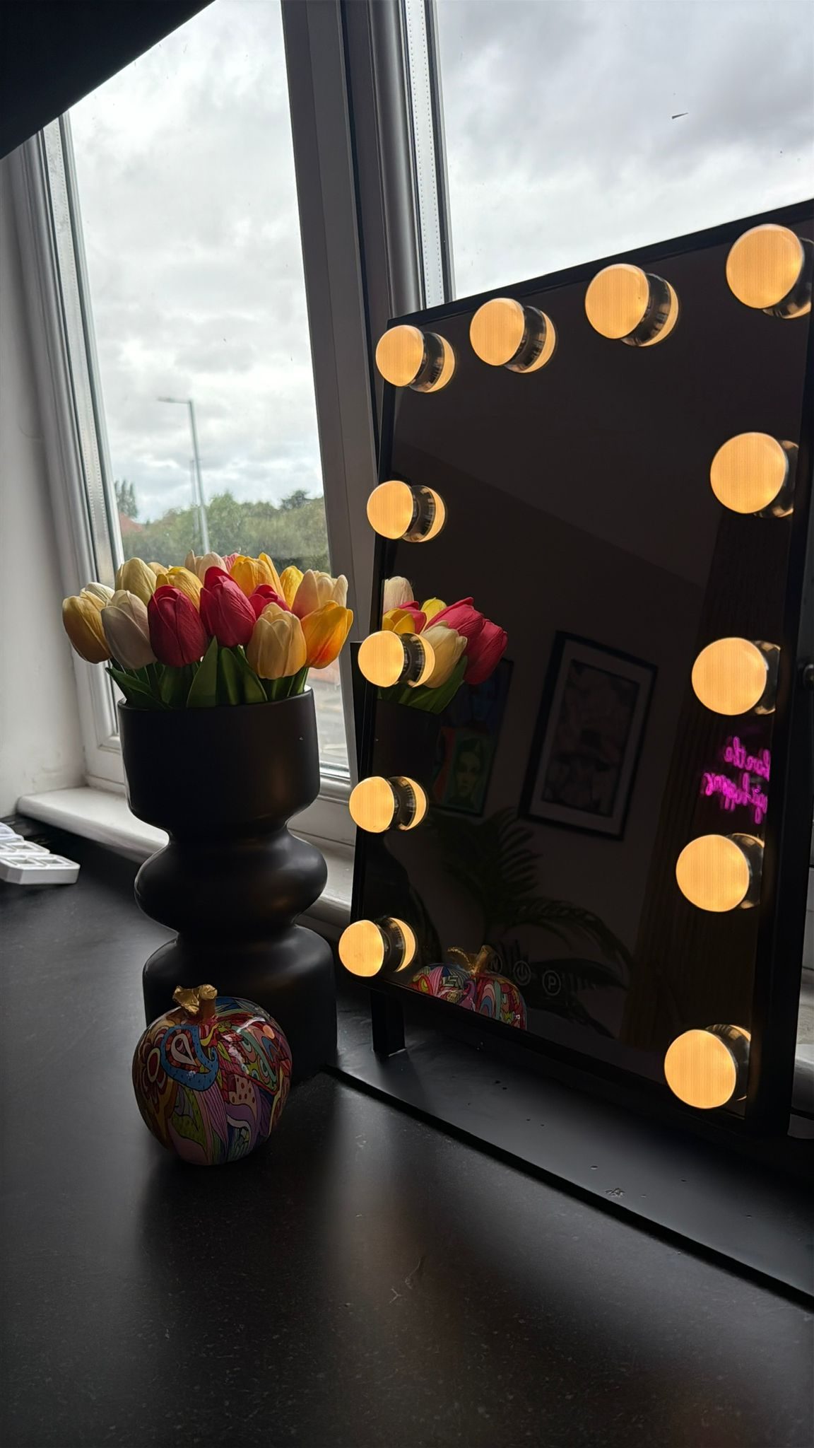 Illuminated vanity mirror and fresh tulips in the studio